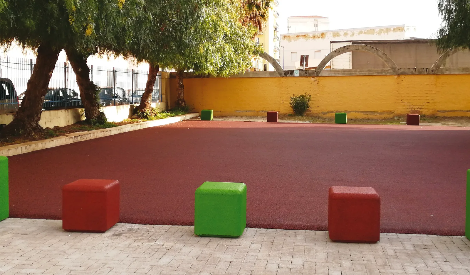 ECO-URBAN 8 Sedute ECO-CUBE rosse e verdi inserite in uno spazio urbano esterno