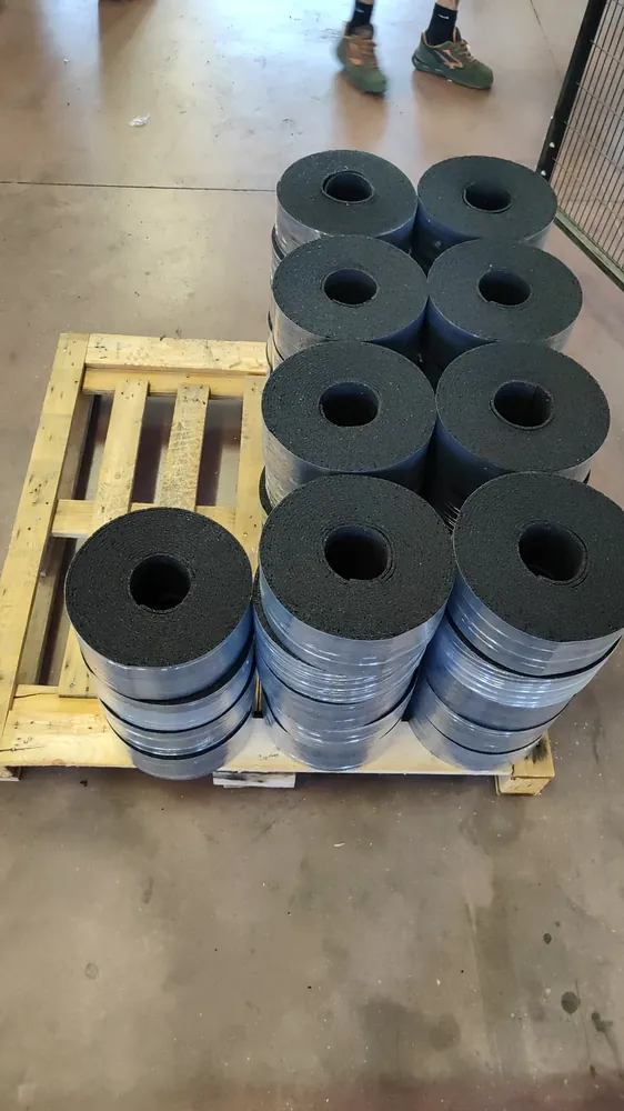 Rouleaux ECO-FON STRIP en caoutchouc recyclé disposés sur des palettes